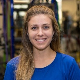 Kirsten Reisinger posing for portrait in front of fitness floor.